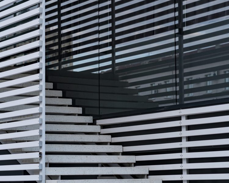 Details of railing and stairs of a modern building and shadow reflection on windows